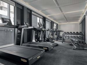 een sportschool met rijen loopbanden en fitnessapparaten bij Mercure ICON Singapore City Centre in Singapore