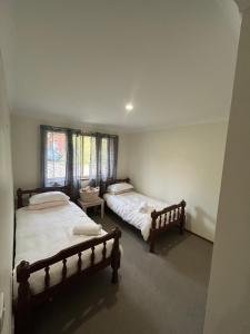 a bedroom with two beds and a window at The little beach house in Tuross Heads