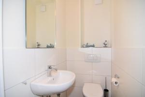 a white bathroom with a sink and a toilet at Luv & Lee, Whg 3 in Westerland
