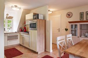a kitchen with a refrigerator and a table with chairs at Entennest im Witthüs in Nieblum