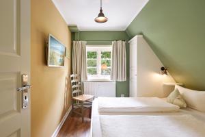 a small room with two beds and a window at Entennest im Witthüs in Nieblum +7 photos