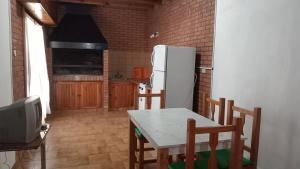 a kitchen with a table and a white refrigerator at Departamento en barrio tranquilo in Mar del Plata