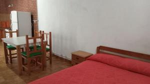 a bedroom with a bed and a table and a refrigerator at Departamento en barrio tranquilo in Mar del Plata +7 photos