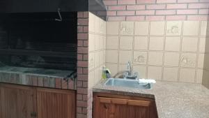 a kitchen with a sink and a brick wall at Departamento en barrio tranquilo in Mar del Plata