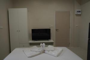 una camera da letto con un letto con asciugamani sopra di Hommory Residence - West Chalong a Ban Klang Altre 19 foto