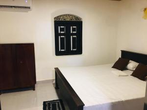 a bedroom with a bed and a window and a door at Madiha Dolamulla Gedara in Kamburugamuwa
