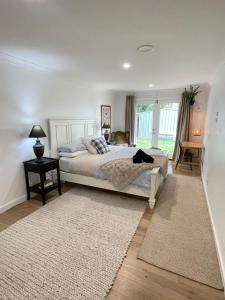 een slaapkamer met een bed, een tafel en een raam bij Cosy Guesthouse in Moss Vale