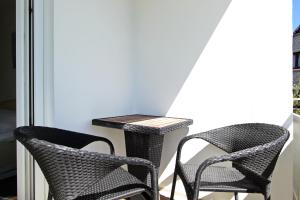 twee stoelen en een tafel op een balkon bij Strandmuschel in Hörnum