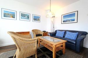 een woonkamer met een bank en een tafel bij Strandmuschel in Hörnum