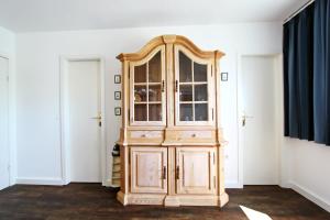 een houten kast in een kamer met twee deuren bij Strandmuschel in Hörnum +2 foto's