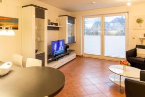 a living room with a television and a table at Stranddüne, D13 in Duhnen