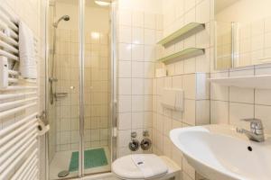 a bathroom with a shower and a sink and a toilet at Stranddüne, D13 in Duhnen