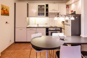 a kitchen with a table and white cabinets at Stranddüne, D13 in Duhnen