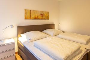 a bed with two pillows on it in a room at Stranddüne, D13 in Duhnen +3 photos