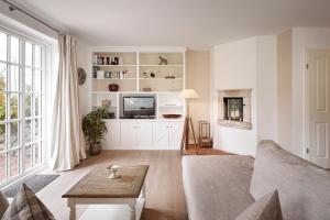 a living room with a couch and a tv at Deichgraf in Dunsum