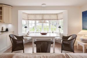 a dining room with a white table and chairs at Deichgraf in Dunsum