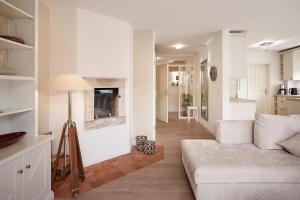 a white living room with a couch and a fireplace at Deichgraf in Dunsum