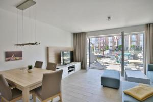a living room with a dining table and a television at City Marina, CM24d in Cuxhaven