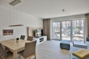 a living room with a table and a dining room at City Marina, CM24d in Cuxhaven