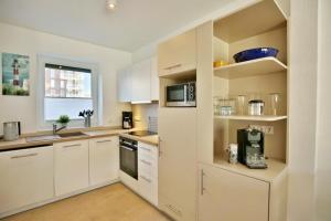 a kitchen with white cabinets and a microwave at City Marina, CM24d in Cuxhaven