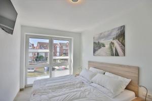 a white bedroom with a bed and a window at City Marina, CM24d in Cuxhaven +15 photos