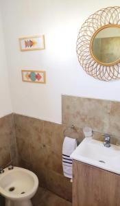 a bathroom with a sink and a toilet and a mirror at Pasos del Dique in Cortaderas