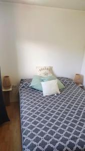 een slaapkamer met een blauw bed met kussens erop bij Pasos del Dique in Cortaderas +34 foto's