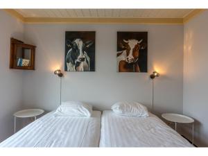 2 letti in una camera con dipinti alle pareti di Lovely Holiday Home in Texel near Sea a Oost