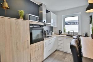 a kitchen with white cabinets and a large appliance at City Marina, CM20b in Cuxhaven