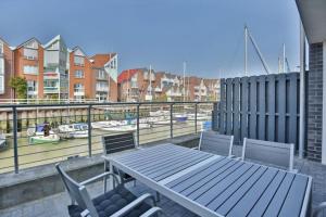 a table and chairs on a balcony with a harbor at City Marina, CM20b in Cuxhaven