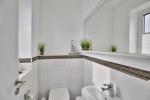 a white bathroom with a sink and a toilet at City Marina, CM20b in Cuxhaven +13 photos