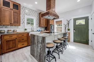 Eine Küche mit Holzschränken und einer großen Kochinsel mit Barhockern in der Unterkunft Oak & Ocean in Destin