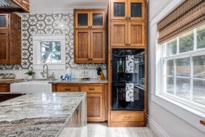 eine Küche mit Holzschränken und einer Marmorarbeitsplatte in der Unterkunft Oak & Ocean in Destin