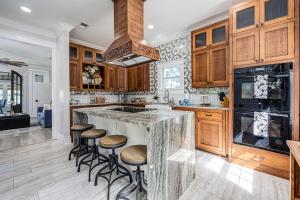 Eine Küche mit einer großen Kochinsel und Barhockern in der Unterkunft Oak & Ocean in Destin