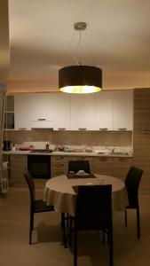 a kitchen with a table with chairs and aendant light at Fralillo House in Verona