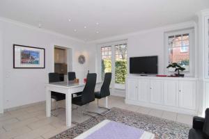 a living room with a table and chairs and a tv at Maybachstraße 22 in Westerland