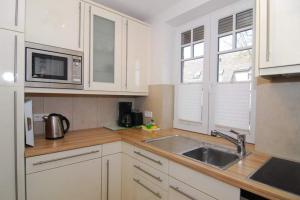 a kitchen with white cabinets and a sink at Maybachstraße 22 in Westerland +17 photos