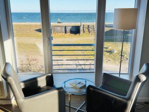 a living room with two chairs and a view of the ocean at Apartment Priwall Teichhof Fehmarn in Wenkendorf