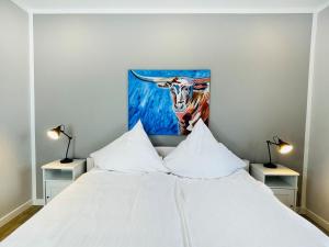 a bedroom with a bed with a painting of a cow at Apartment Priwall Teichhof Fehmarn in Wenkendorf