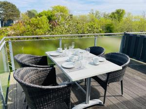 a white table and chairs on a balcony at Apartment Priwall Teichhof Fehmarn in Wenkendorf +30 photos