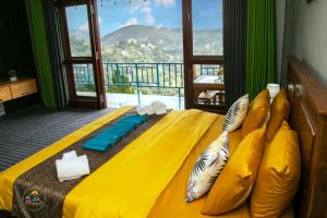 a bedroom with a yellow bed with a view at Ella T&D Resort in Ella
