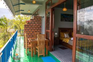 a room with a balcony with a table and a bed at Ella T&D Resort in Ella