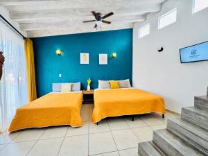 2 letti in una camera con parete blu di Casa Rinconcito Del Sol Alberca Climatizada a Tonatico
