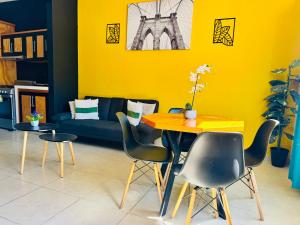 un soggiorno giallo con tavolo e sedie di Casa Rinconcito Del Sol Alberca Climatizada a Tonatico Altre 10 foto