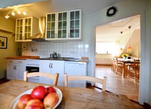 a kitchen with a table with a bowl of fruit on it at Im Apfelgarten in Oldsum