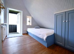 a bedroom with a blue bed and a staircase at Im Apfelgarten in Oldsum +3 photos