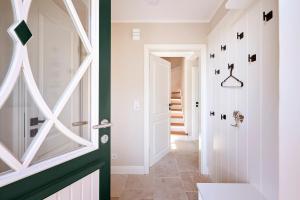 a bathroom with green and white walls and a door at Reethaus Friesenjung in Hedehusum