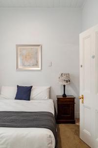 una camera da letto con un letto e un tavolo con una lampada di Seaview House a Queenscliff