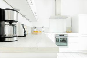 a kitchen with white cabinets and a counter top at Amoy - Werftstraße 2 in Heiligenhafen