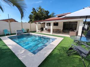 a swimming pool with a table and a house at Casa Tribu in Agujas